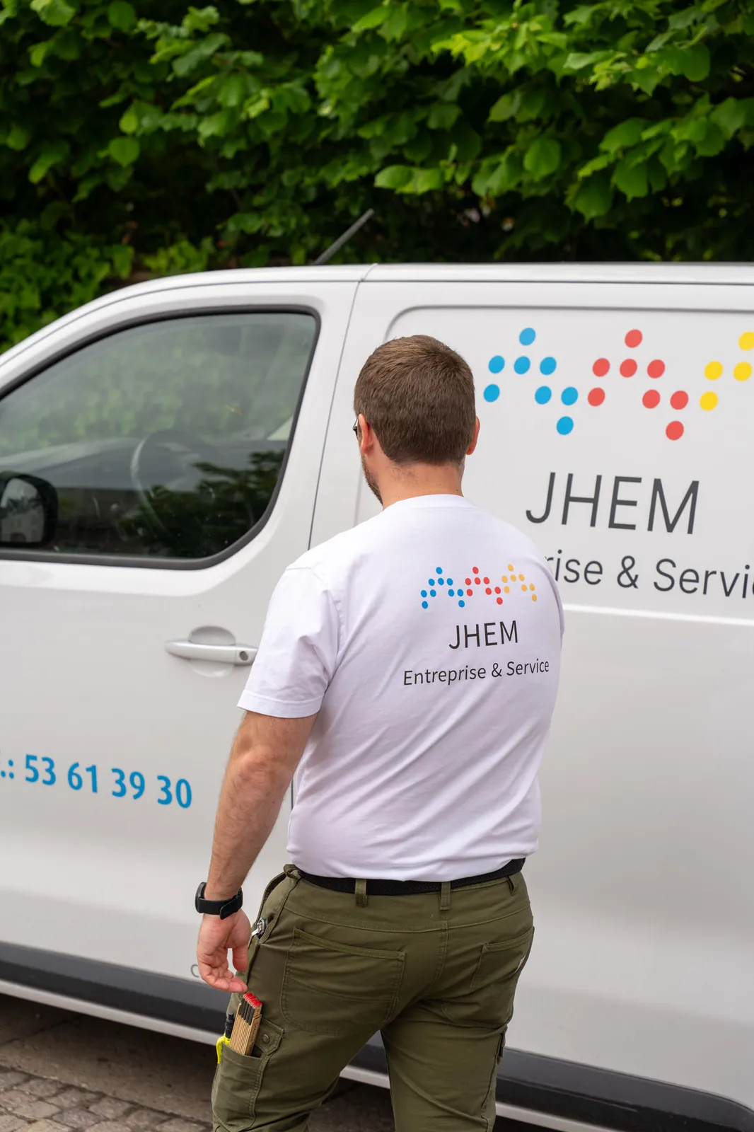 Håndværker fra JHEM Entreprise ved firmabilen på vej til en opgave
