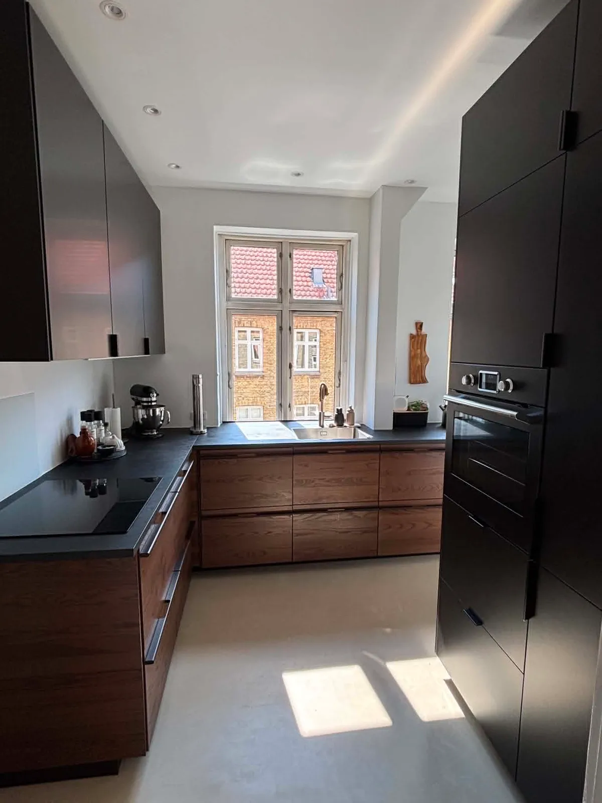 Nyt køkken i valnød med sort bordplade på Amager