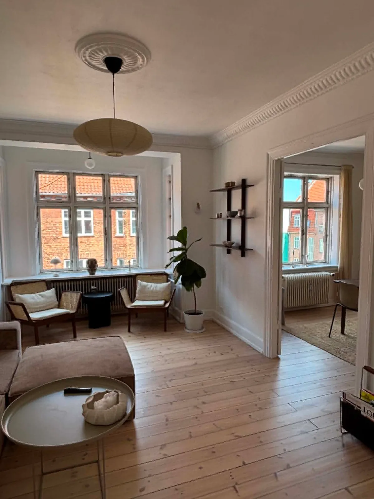 Lys stue med sildebensgulv og store vinduer på Amager